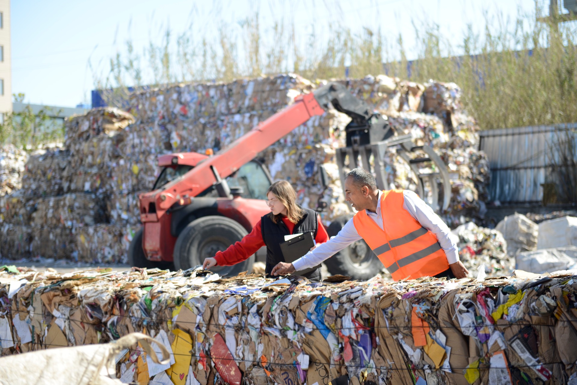 Environmental engineer and ancillary staff examining waste at high-tech recycling facility